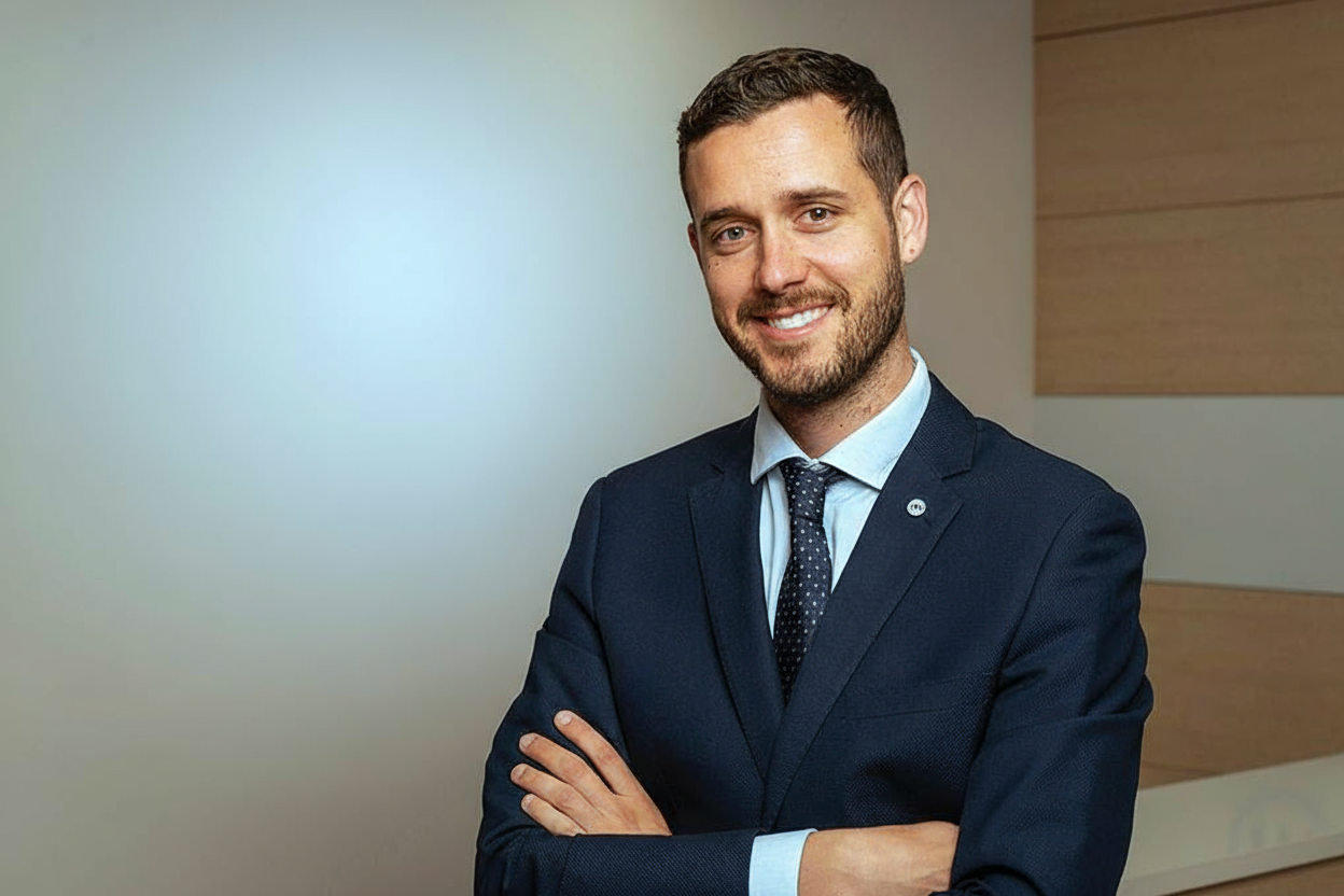 Eloy López con los brazos cruzados vestido de traje